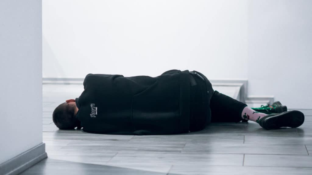 Can you sleep overnight in an airport? Man sleeping on the floor.