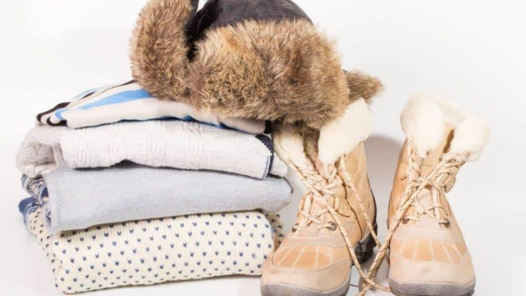 Folded clothes, fur hat and boots_What To Pack For Alaska